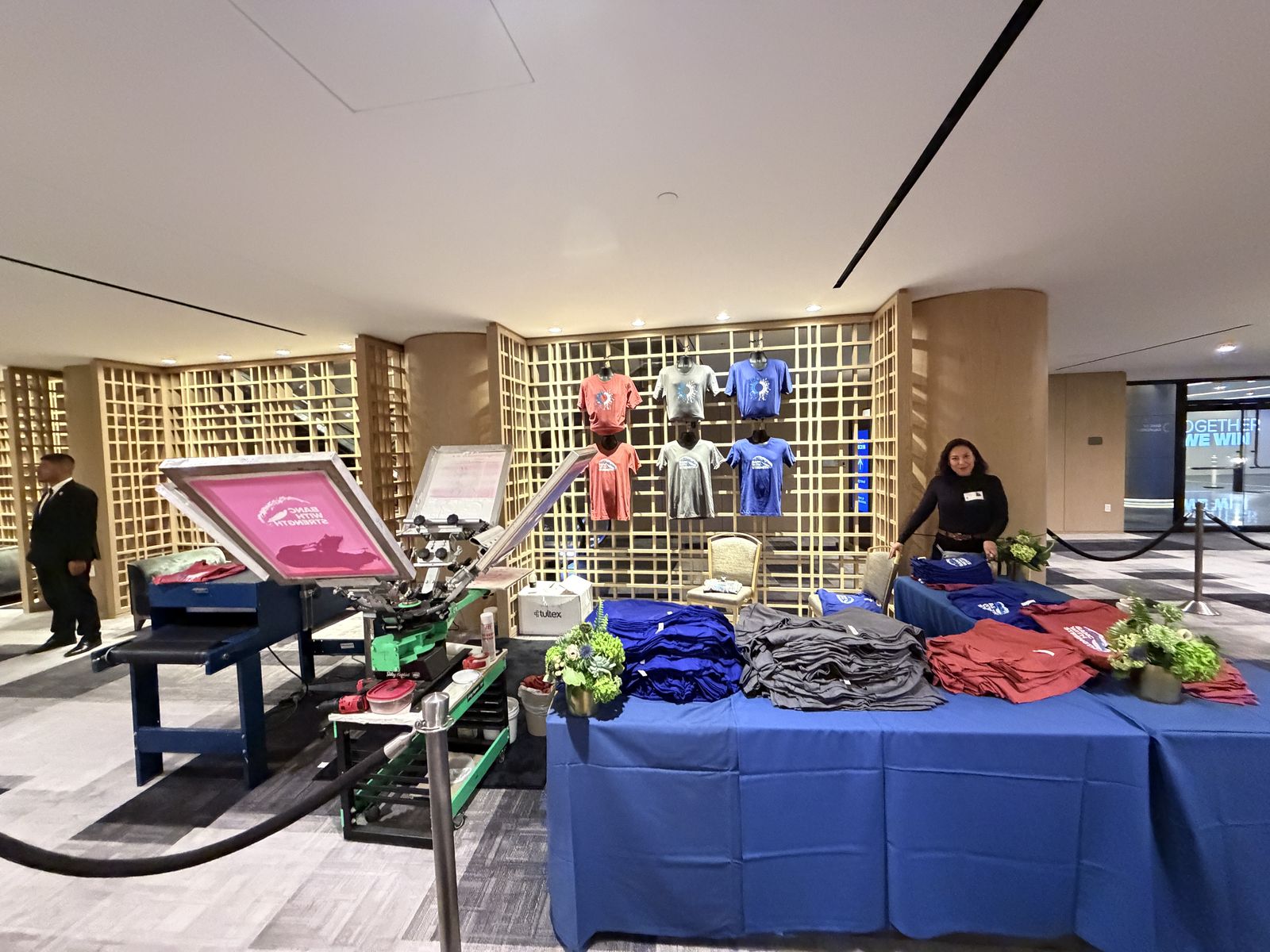 Fully staged station with garments displayed on a lattice wall before an event begins